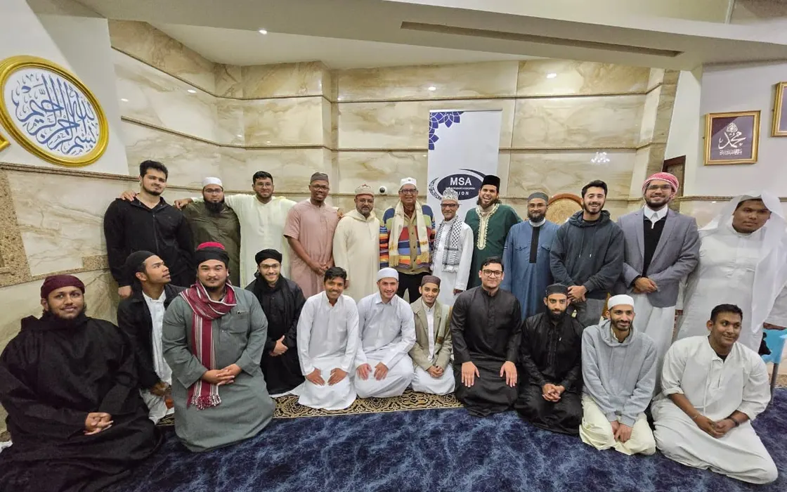 Members and guests gathered in a mosque for the MSA Union fiftieth anniversary, in front of an MSA banner